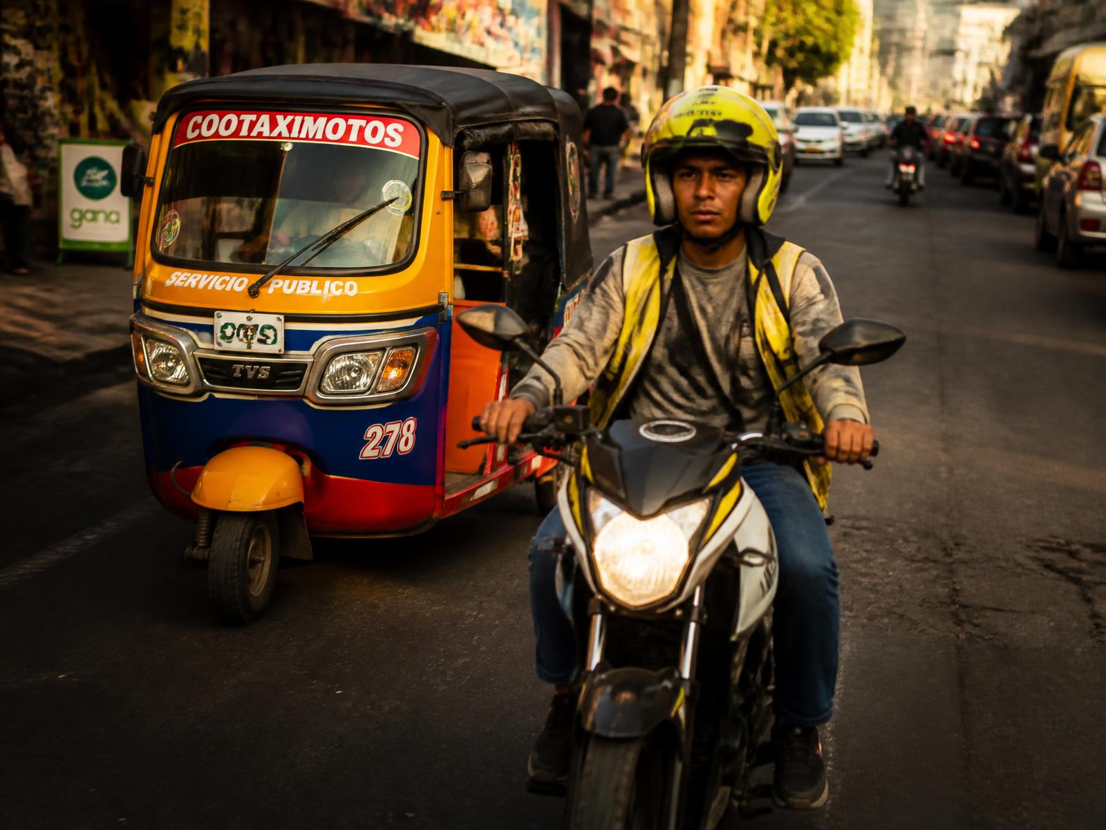 Mototaxista y motocarro esperando pasajeros en una calle de la ciudad